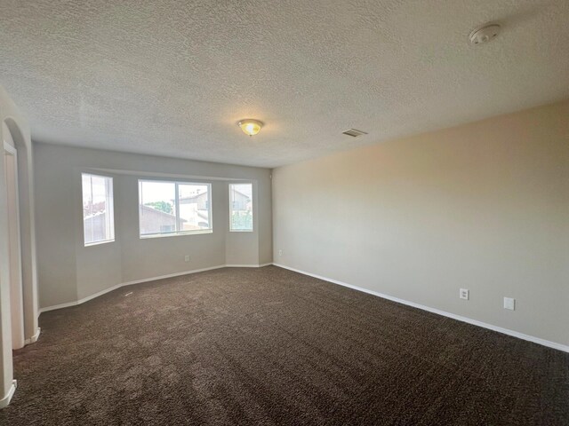 unfurnished room featuring a textured ceiling and carpet flooring