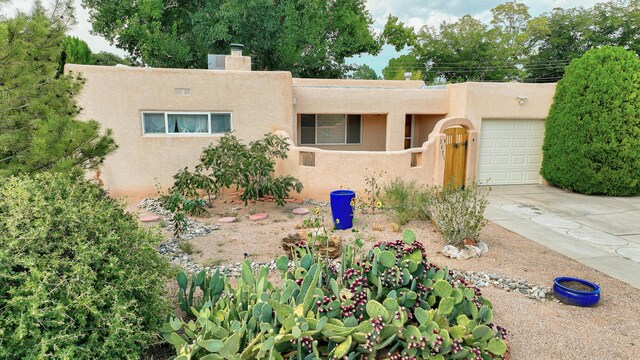 pueblo revival-style home with a garage