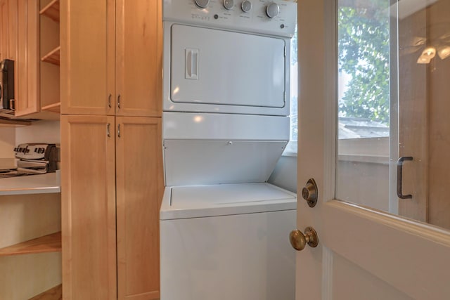 laundry area with stacked washer / dryer and laundry area