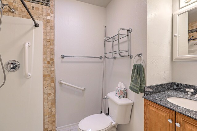 bathroom featuring vanity, toilet, and tiled shower