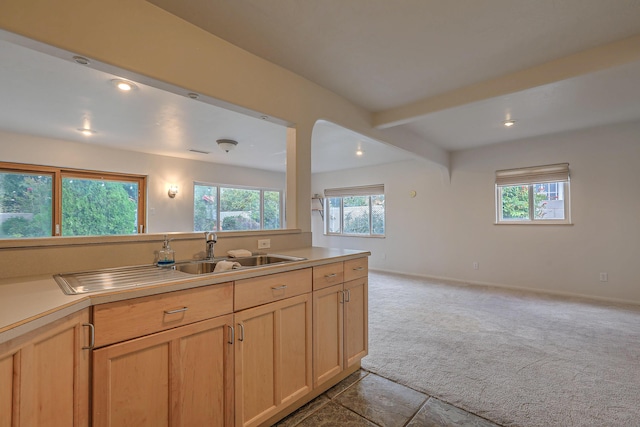 kitchen with light colored carpet, light countertops, a sink, and light brown cabinets