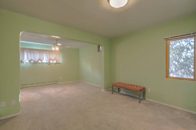 unfurnished room with baseboards, a baseboard heating unit, and light colored carpet