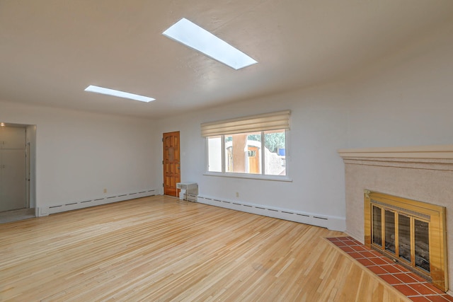 unfurnished living room with a baseboard heating unit, a skylight, a fireplace, and wood finished floors