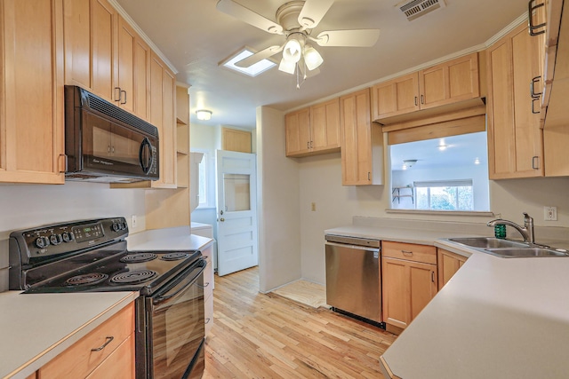 kitchen with light countertops, visible vents, light brown cabinets, a sink, and black appliances