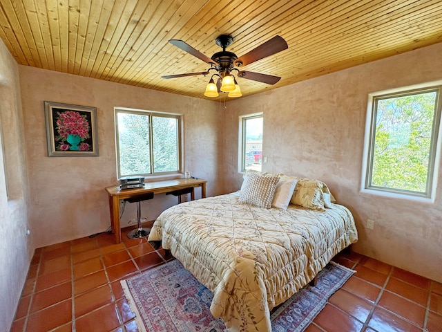 bedroom featuring multiple windows, ceiling fan, and tile patterned floors