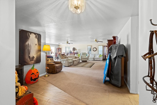 living room with a wealth of natural light, ceiling fan, wood finished floors, and a textured ceiling