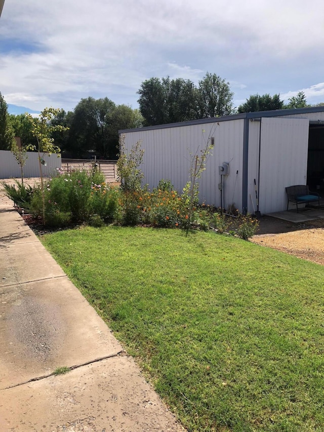 view of yard featuring an outbuilding and fence