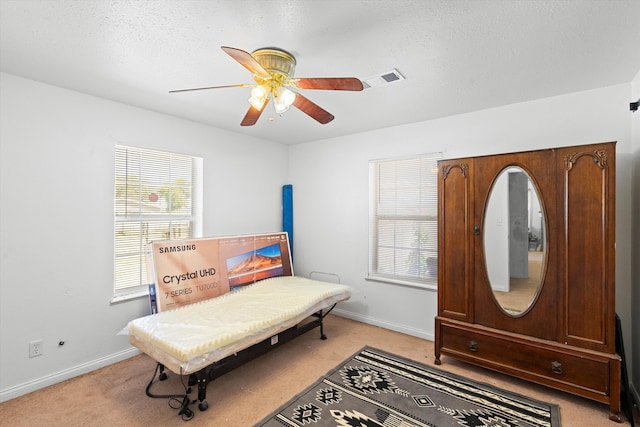 bedroom with visible vents, baseboards, ceiling fan, and light colored carpet