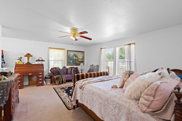carpeted bedroom featuring a ceiling fan and a textured ceiling