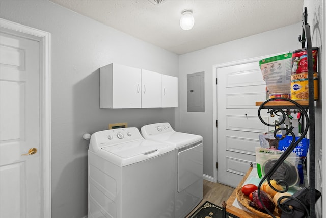 washroom with cabinets, light wood-type flooring, a textured ceiling, electric panel, and washer and clothes dryer