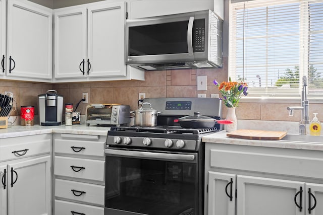 kitchen with stainless steel appliances, tasteful backsplash, and light countertops