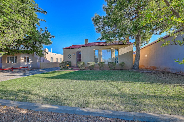 mediterranean / spanish home featuring a front lawn