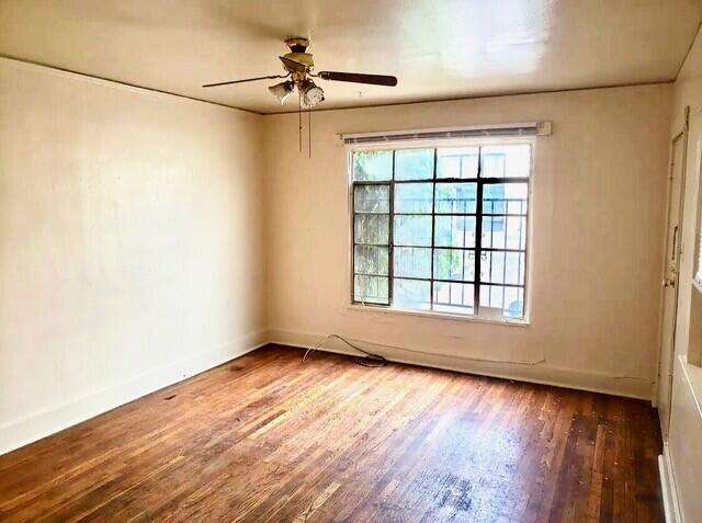 unfurnished room featuring ceiling fan and dark wood-type flooring