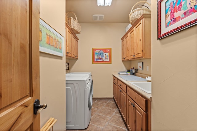 laundry area featuring light tile patterned floors, cabinets, sink, and independent washer and dryer