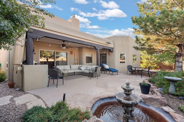 rear view of property with an outdoor living space, a patio, and ceiling fan