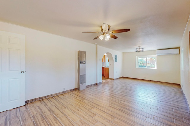 unfurnished room featuring ceiling fan, a wall mounted air conditioner, and light hardwood / wood-style flooring