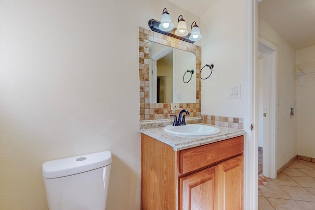 bathroom with tile patterned flooring, vanity, toilet, and backsplash