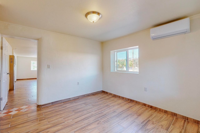 unfurnished room with light hardwood / wood-style flooring and a wall mounted air conditioner