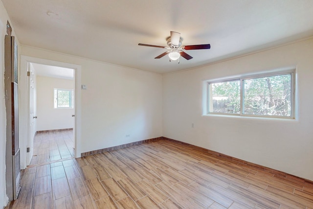 spare room with ceiling fan and light wood-type flooring