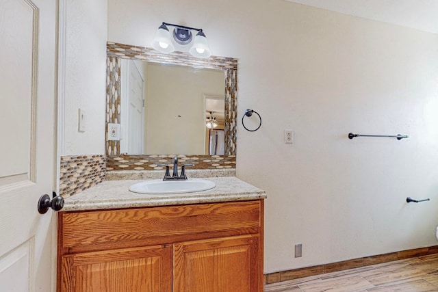 bathroom featuring vanity, wood-type flooring, and backsplash