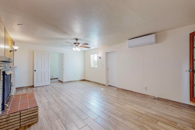 unfurnished living room with light wood-type flooring, ceiling fan, an AC wall unit, and a textured ceiling