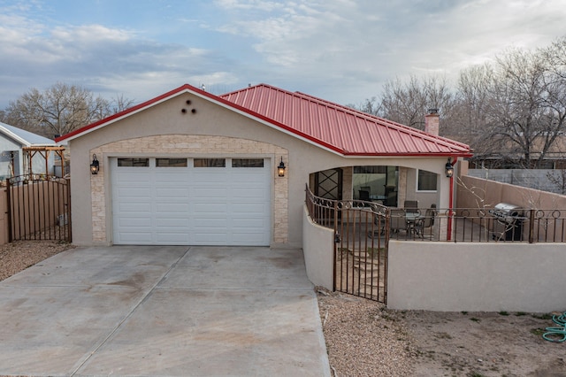 view of front of home featuring fence, concrete driveway, stucco siding, a garage, and a gate