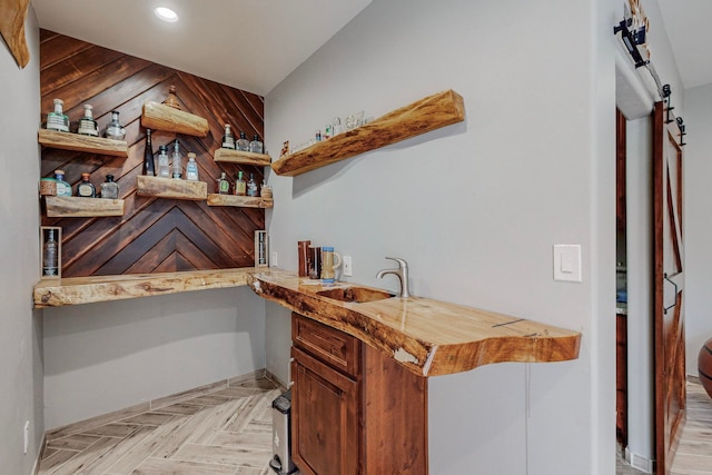 interior space with wooden walls, light parquet floors, and sink