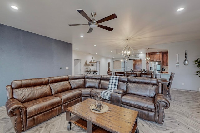 living room with ceiling fan with notable chandelier and light parquet floors