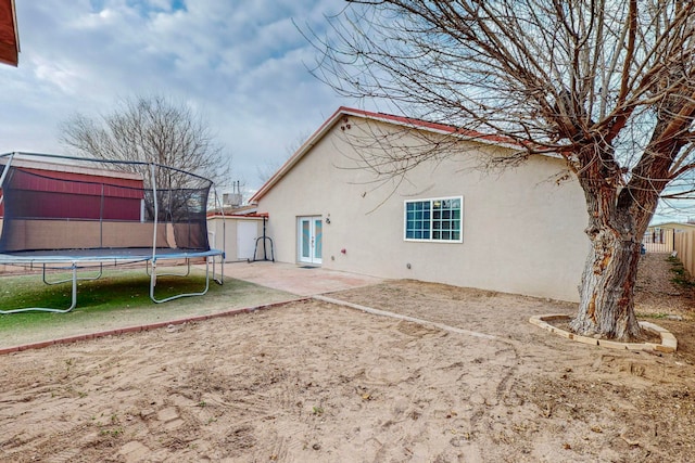 rear view of house with a patio and a trampoline