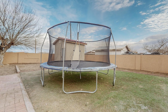 view of yard with a trampoline and fence