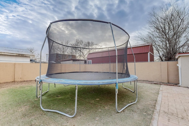 view of yard with a trampoline and fence