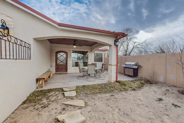 view of patio featuring a grill, a ceiling fan, and fence