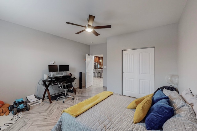 bedroom featuring light parquet flooring, ceiling fan, and a closet