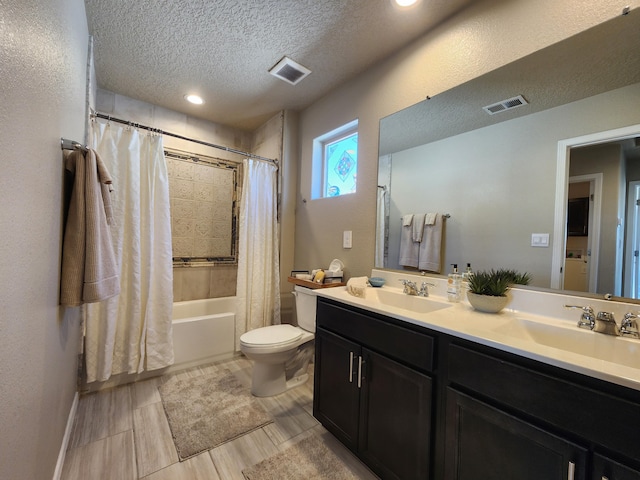 full bathroom with visible vents, shower / bathtub combination with curtain, toilet, a sink, and a textured ceiling