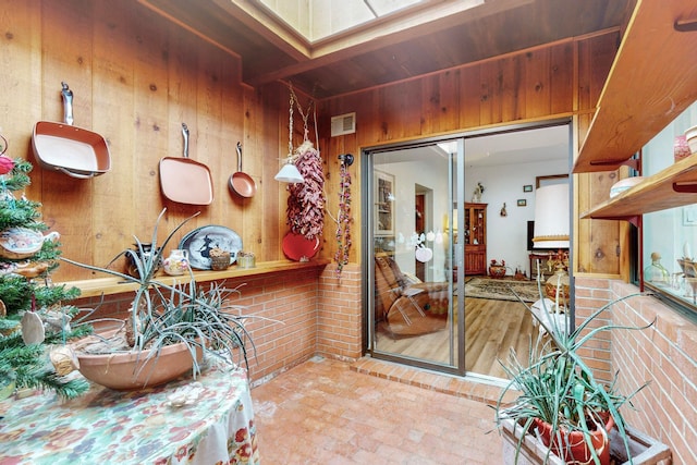 interior space with hardwood / wood-style flooring and wooden walls