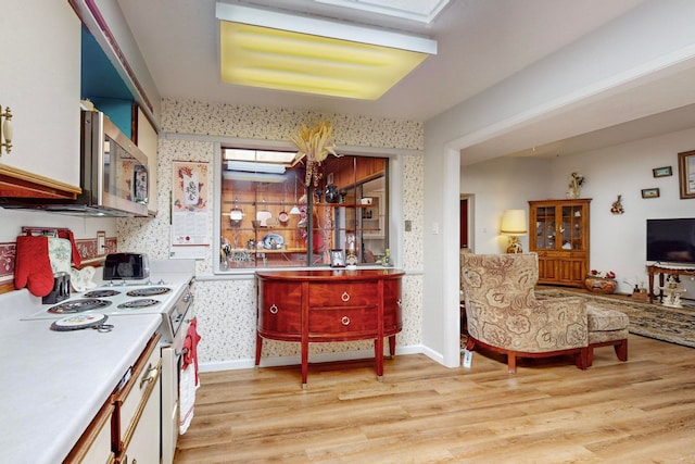 kitchen featuring white electric range oven, white cabinetry, and light hardwood / wood-style floors