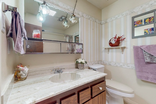 bathroom featuring vanity, toilet, and curtained shower