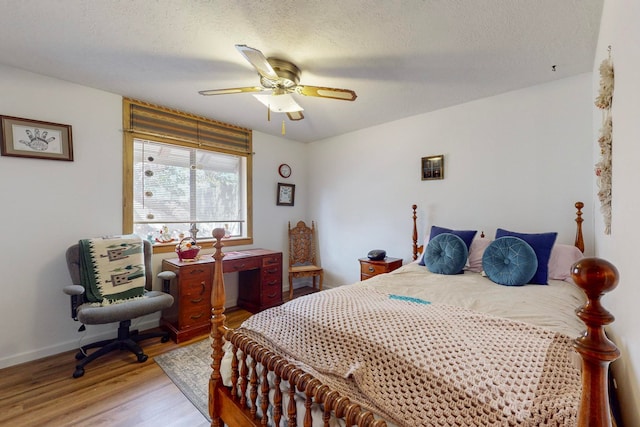 bedroom with a textured ceiling, ceiling fan, and hardwood / wood-style flooring