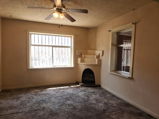 unfurnished living room with a textured ceiling, ceiling fan, and carpet flooring