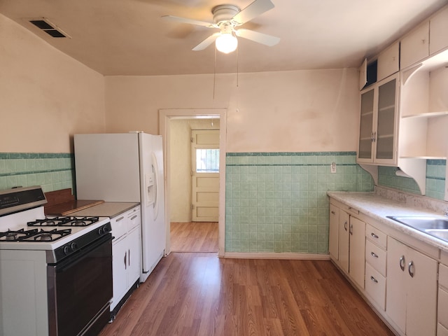 kitchen featuring white appliances, wood-type flooring, sink, ceiling fan, and white cabinets