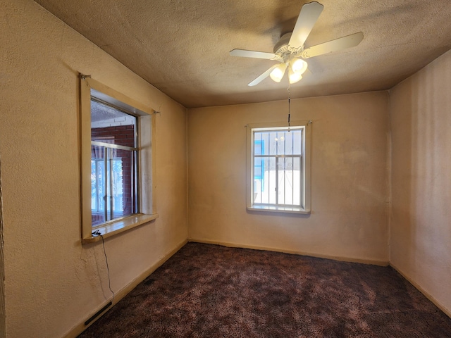 carpeted empty room featuring ceiling fan and a textured ceiling