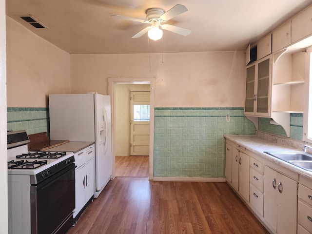 kitchen featuring white appliances, white cabinetry, sink, dark hardwood / wood-style floors, and ceiling fan