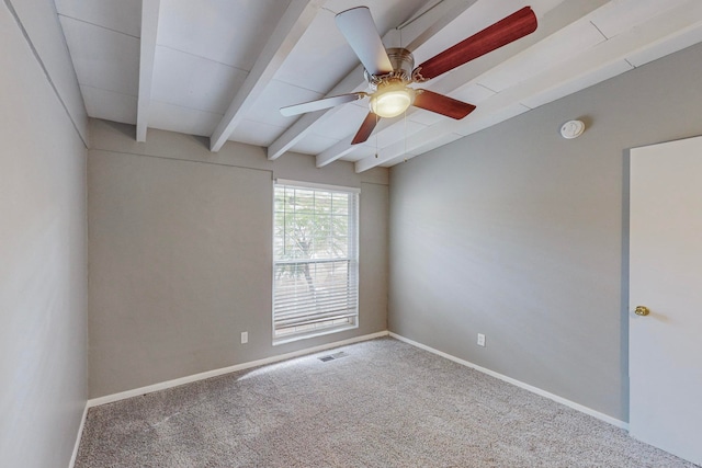 spare room with ceiling fan, vaulted ceiling with beams, and carpet floors