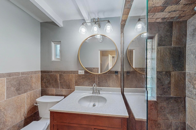 bathroom with tile walls, beamed ceiling, vanity, and toilet