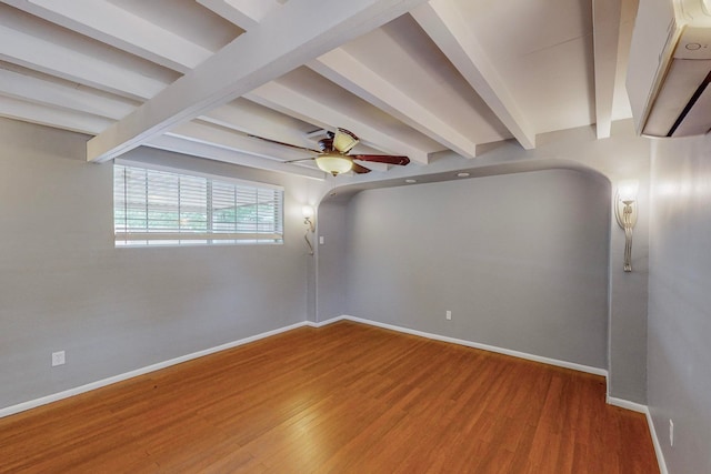 spare room with wood-type flooring, ceiling fan, and beamed ceiling