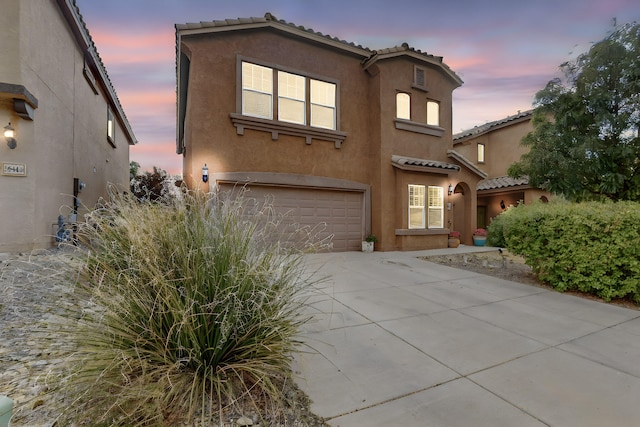 mediterranean / spanish-style home with a garage