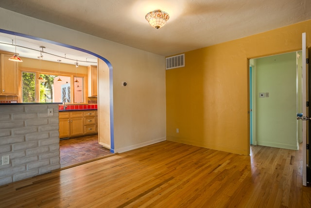 unfurnished living room with dark hardwood / wood-style flooring and sink