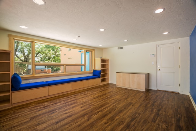 unfurnished room featuring a textured ceiling and dark wood-type flooring