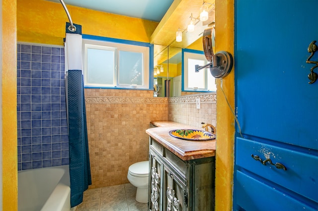 full bathroom with tile patterned flooring, shower / bath combo, toilet, tile walls, and vanity