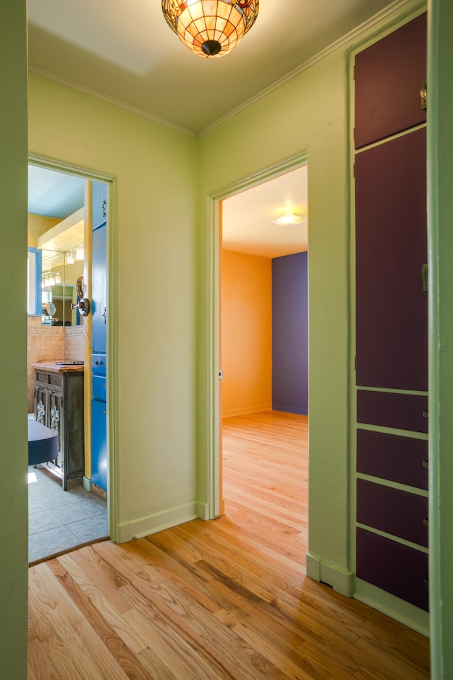 corridor featuring ornamental molding and light wood-type flooring